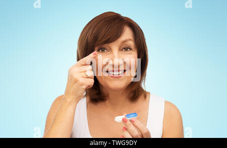 Felice donna senior di applicare le lenti a contatto Foto Stock