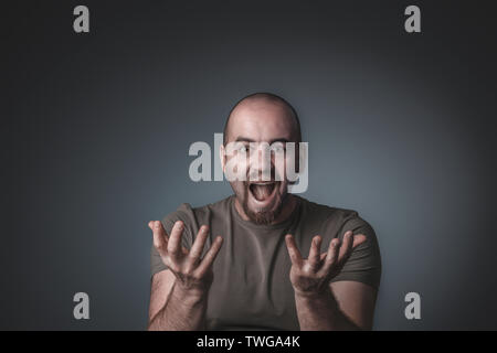 Studio shot di un uomo con un sorpreso ed entusiasta di espressione con mani aperte davanti a lui Foto Stock