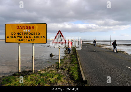 Gli avvisi "Tide Times" prima di attraversare la strada rialzata per Holy Island a Northumberland, in Gran Bretagna, la piccola isola di marea è accessibile solo Foto Stock