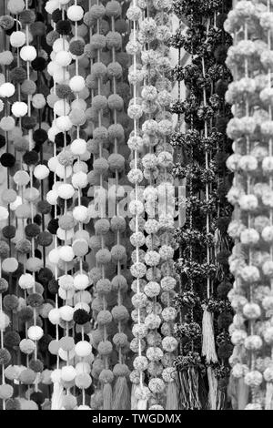 Decorativo-pom pom appesa in un Chiapas mercato come una texture di sfondo in un sorprendente in bianco e nero Foto Stock
