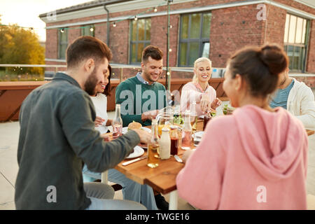 Amici a cena o festa sul tetto in estate Foto Stock