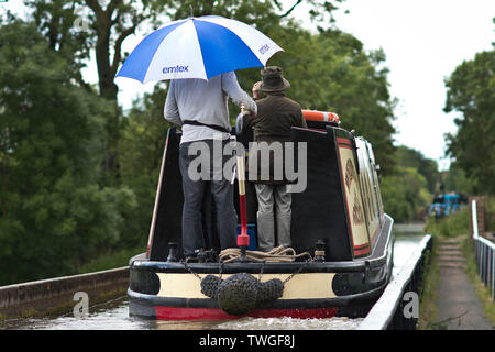 I vacanzieri riparo dalla pioggia su una croce narrowboat l acquedotto Edstone durante una calda e piacevole giornata nel Warwickshire, Regno Unito. Il 20 giugno 2019. Foto Stock