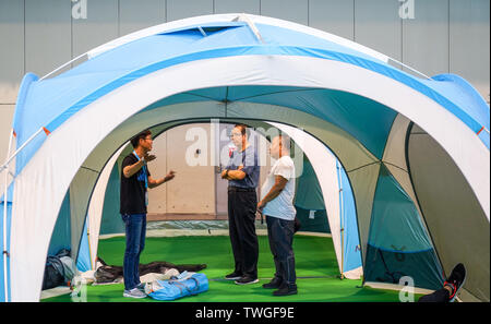 (190620) -- NANJING, 20 giugno 2019 (Xinhua) -- Un personale (L) introduce una tenda di visitatori durante l'Asia-Pacifico spettacolo all'aperto 2019 in Nanjing East cinese della provincia di Jiangsu, 20 giugno 2019. (Xinhua/Li Bo) Foto Stock