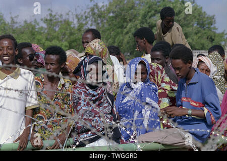 5 novembre 1993 somali locale coda dietro al filo spinato all'ingresso della sede UNOSOM composto a Mogadiscio, in Somalia. Foto Stock