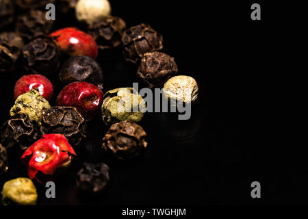 Colorate peperoncino essiccato mix su uno sfondo scuro, macro close-up Foto Stock