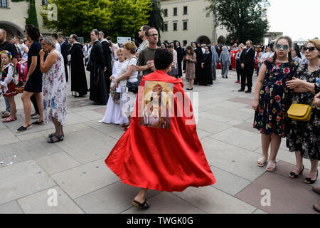 Un credente vestito con un mantello rosso durante una processione religiosa marcatura la Chiesa Cattolica Romana festa del Corpus Christi che celebra la presenza del corpo e del sangue di Gesù Cristo. Foto Stock