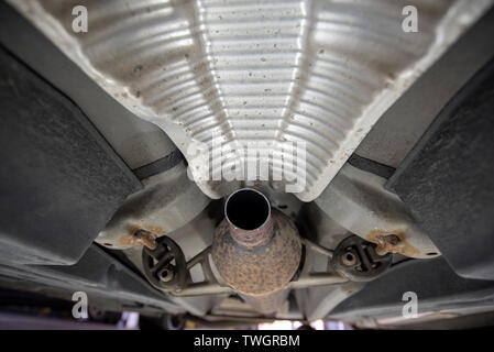 La Toyota Prius, rubato il convertitore catalitico. Vista al di sotto del veicolo dalla meccanica di un pozzetto di ispezione, che mostra la posizione del mancante e i componenti danneggiati. Foto Stock