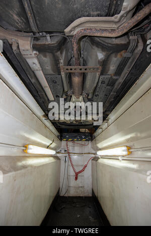 La Toyota Prius, rubato il convertitore catalitico. Vittima di un furto di sistema di scarico. Meccanica pozzetto di ispezione, che mostra la posizione dei componenti danneggiati. Foto Stock