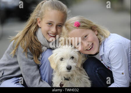 Due sorelle con i loro incroci di cane su un marciapiede di Düsseldorf, Germania. Foto Stock