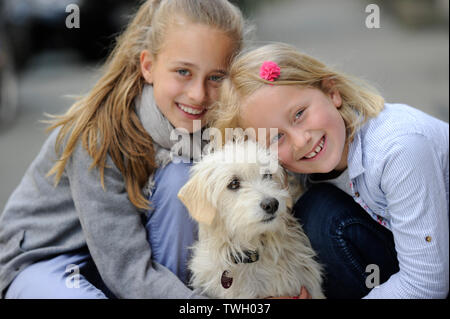 Due sorelle con i loro incroci di cane su un marciapiede di Düsseldorf, Germania. Foto Stock
