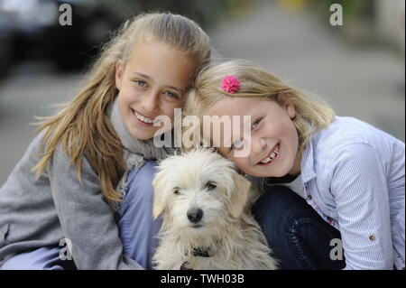 Due sorelle con i loro incroci di cane su un marciapiede di Düsseldorf, Germania. Foto Stock