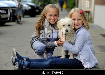 Due sorelle con i loro incroci di cane su un marciapiede di Düsseldorf, Germania. Foto Stock