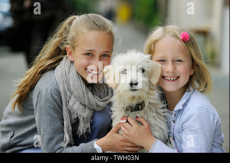 Due sorelle con i loro incroci di cane su un marciapiede di Düsseldorf, Germania. Foto Stock