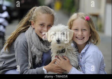 Due sorelle con i loro incroci di cane su un marciapiede di Düsseldorf, Germania. Foto Stock