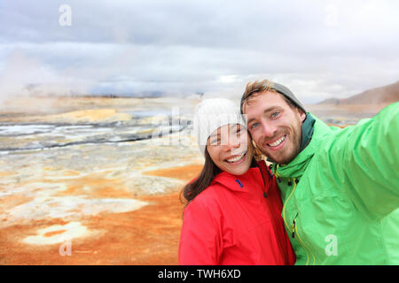 In Islanda il turista giovane tenendo selfie foto con la fotocamera dello smartphone al landmark destinazione: Namafjall hverir Hverarondor mudpot chiamato anche piscina di fango caldo o a molla fumarola. Bellissima natura Islandese. Foto Stock