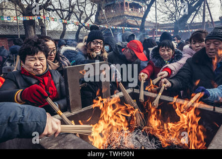 Persone bruciare incensi in Yonghe Tempio chiamato anche il Tempio Lama della scuola Gelug del buddhismo tibetano nel distretto di Dongcheng a Pechino, Cina Foto Stock