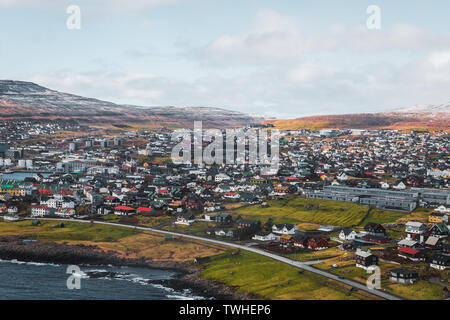 Ripresa aerea della città Torshavn come prese durante un volo in elicottero su un inizio di mattina di primavera con montagne coperte di neve (Isole Faerøer, Danimarca) Foto Stock