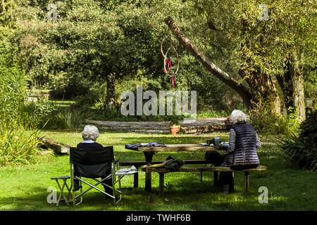 Due pensionati seduti all'ombra in una giornata di sole pittura still life Foto Stock