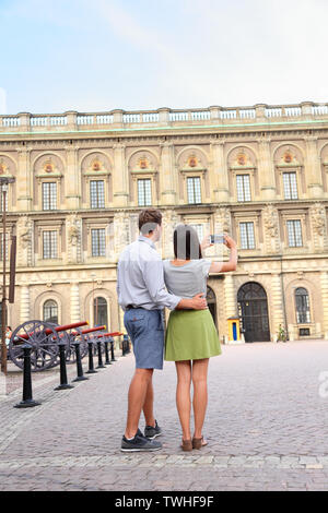 Il turista giovane prendendo foto di foto con lo smartphone del Palazzo Reale di Stoccolma, Svezia, l'Europa. Turisti felici le persone a visitare attrazioni in Gamla Stan, la città vecchia di Stoccolma. Foto Stock