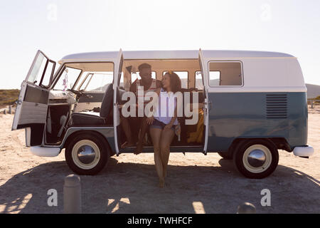 Coppia felice divertendosi in camper presso la spiaggia Foto Stock