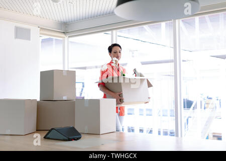 Imprenditrice che trasportano le scatole di cartone nel nuovo ufficio Foto Stock