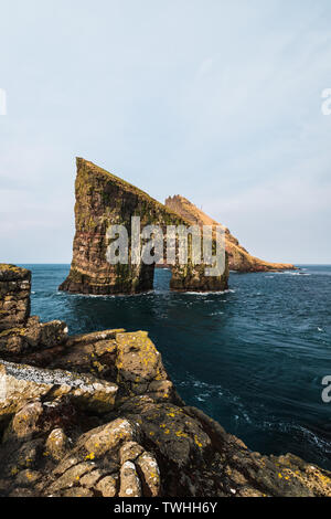 Close-up shot del famoso Drangarnir scogliera con isole Tindholmur in background presi durante la mattina presto escursione in primavera (Isole Faroe, Danimarca) Foto Stock