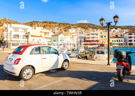 Porto di Pigadia, isola di Karpathos - Sep 26, 2018: Elegante Fiat 500 parcheggio nel pittoresco porto di Pigadia sull isola di Karpathos al tramonto, Grecia. Foto Stock