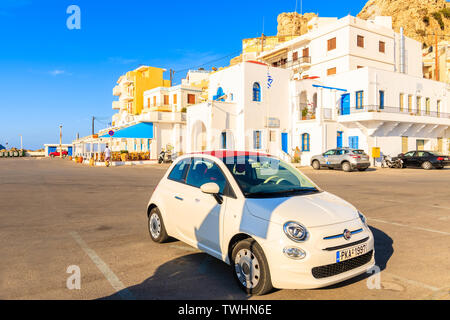 Porto di Pigadia, isola di Karpathos - Sep 26, 2018: Elegante Fiat 500 parcheggio nel pittoresco porto di Pigadia sull isola di Karpathos al tramonto, Grecia. Foto Stock