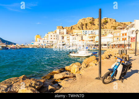 Parcheggio scooter in bella Pigadia porto dei pescatori al tramonto del tempo, Karpathos Island, Grecia Foto Stock