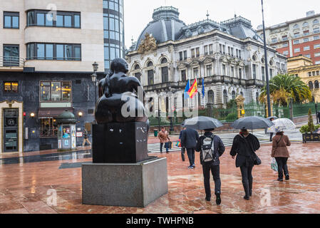 La Maternidad (maternità) statua realizzata da Fernando Botero Angul sulla Plaza de la Escandalera a Oviedo, Spagna, vista con ufficio di autorità locali Foto Stock