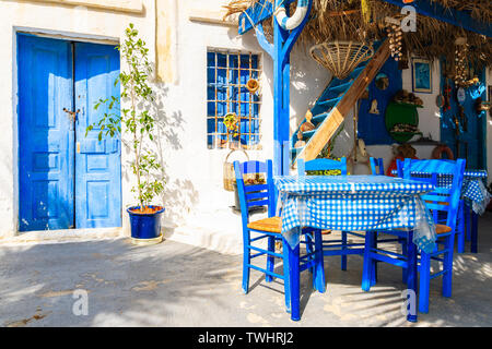 Tabella nella parte anteriore del tipico greco casa sulla strada di Finiki village, Karpathos Island, Grecia Foto Stock