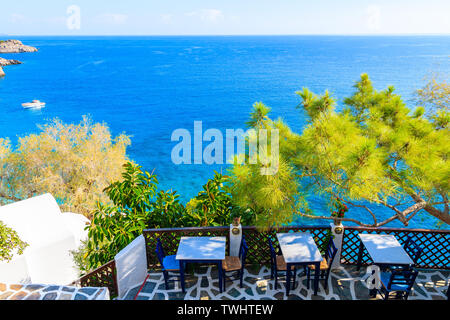 Terrazza con tavoli in una tradizionale taverna greca in Kyra Pynagia bay con bella vista mare a Karpathos Island, Grecia Foto Stock