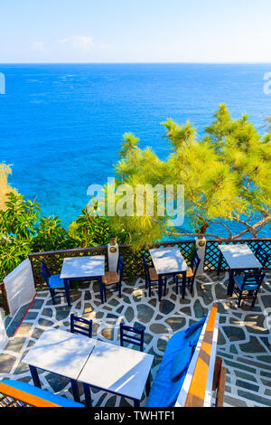 Terrazza con tavoli in una tradizionale taverna greca in Kyra Pynagia bay con bella vista mare a Karpathos Island, Grecia Foto Stock