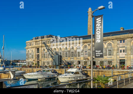 Persone godetevi il sole presso la popolare waterside attrazione turistica della Royal William Yard in Plymouth, Devon. Foto Stock