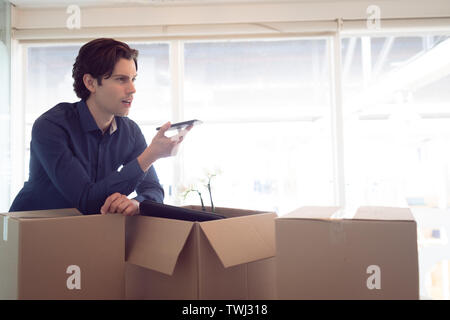 Executive maschio parlando al telefono cellulare in ufficio Foto Stock