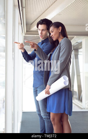 Maschio e femmina architetti interagire gli uni con gli altri in ufficio Foto Stock