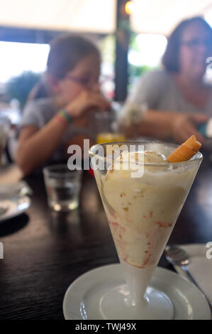 Turisti che si godono il gelato in una gelateria in estate a Cannes Riviera francese Foto Stock