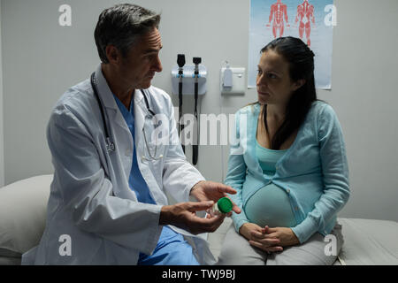 Medico dando la prescrizione a donne in stato di gravidanza della donna Foto Stock