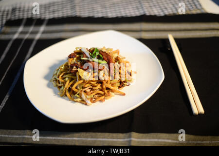 Cinese riso fritto a base di noodle con carne di manzo, setup bene sulla tabella pronto a servire Foto Stock