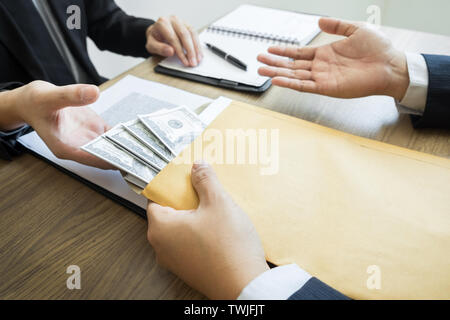 Corrompere e concetto di corruzione, imprenditore corrotto la tenuta la trattativa lato ricezione venality corrompere i soldi dal partner. Foto Stock