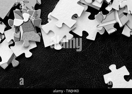 Bambini i puzzle su sfondo scuro vicino. In bianco e nero Foto Stock