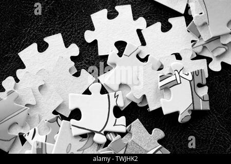 Bambini i puzzle su sfondo scuro vicino. In bianco e nero Foto Stock