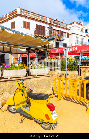 TOSSA DE MAR, Spagna - giu 6, 2019: Yellow Classic scooter parcheggio sulla spiaggia nella bellissima città di Tossa de Mar che è una località balneare sulla Costa Brava, Foto Stock