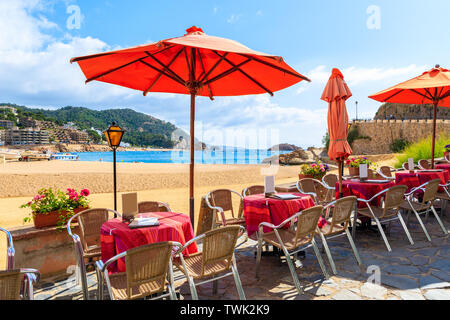 Tavole di ristorante sulla spiaggia di Tossa de Mar che è una località balneare sulla Costa Brava, Spagna Foto Stock