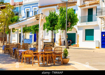 Tavole di ristorante sulla strada del piccolo villaggio di pescatori di Llafranc, Costa Brava, Spagna Foto Stock