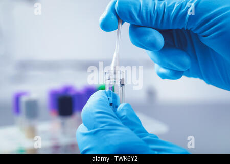 Scienziato in lab raccogliere un campione di dna in provetta con un batuffolo di cotone Foto Stock