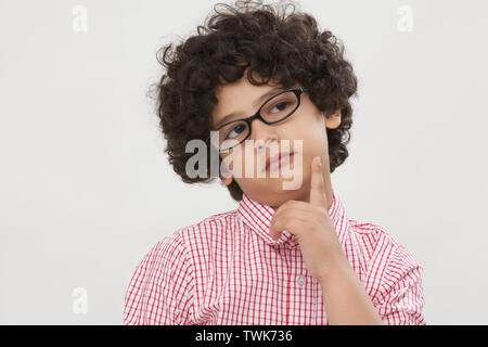 Primo piano di un ragazzo con la mano sul mento Foto Stock