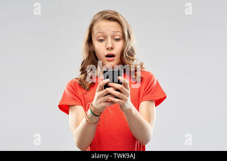 Terrorizzato ragazza adolescente utilizza lo smartphone Foto Stock