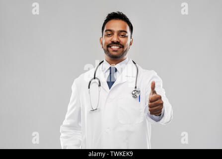 Sorridente maschio indiano medico mostrando pollice in alto Foto Stock