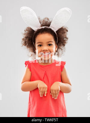 Felice bambina indossa coniglietto pasquale per le orecchie Foto Stock